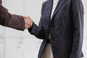 Two businesswomen shaking hands to signify successful business investment agreement and the...