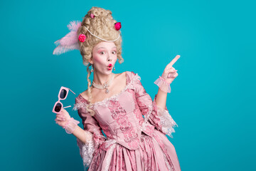 Photo of young aristocratic woman point finger empty space wear baroque dress isolated on teal...