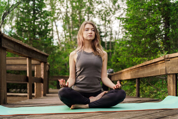 Mindful meditation practice on a tranquil wooden path surrounded by nature's greenery