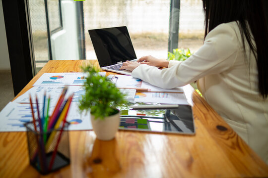 Asian businesswoman checking and analyzing business data for accuracy before starting investment plan to get more profit. Concept of collecting data to analyze investment business to get more profit.