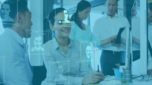 Pointing coworker initiating face scan on monitor highlighting face as tech team collaborating