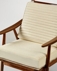 Elegant wooden armchair with cream cushions presenting comfortable and stylish seating