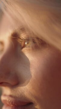 Close up of a woman with blonde hair and blue eyes gazing into the sunlight. Ideal for themes of beauty, tranquility, hope.