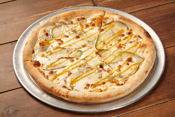 Delicious pizza with pears, gorgonzola and honey on wooden table