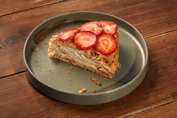 Delicious mille-feuille cake with fresh strawberries on wooden table