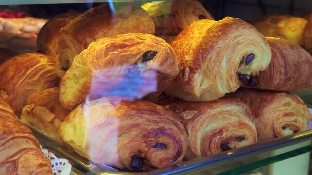 Golden brown pain au chocolat filled with dark chocolate displayed on a tray in a Parisian bakery, tempting passersby with their delicious aroma