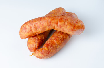 Three raw smoked sausages on white background in studio lighting for food packaging, advertising, and culinary use