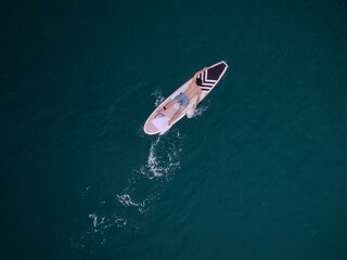 Surfer top of wave in ocean, top view aeria. surfer waiting on beach for the next big wave.