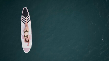 Portrait of surfer woman surfing having fun on Beach. top view of woman lying on surfboard....