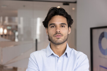 Head shot portrait of skilled Hispanic businessman, project manager looking at camera with...