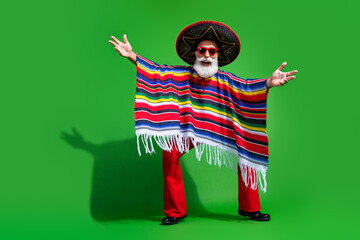 Charismatic man in festive Mexican attire posing with enthusiasm against a vibrant green background