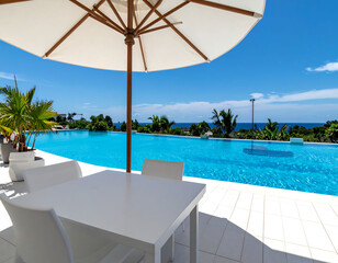 Luxury lifestyle, vibrant pool merging with the ocean horizon under a clear blue sky. Represents relaxation, vacation dreams, and highend living. Ideal for travel, real estate.