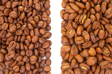 Two piles of roasted coffee beans with varying shades of brown, divided by a white background, showcasing their rich textures and natural splits. Ideal for coffee themes.