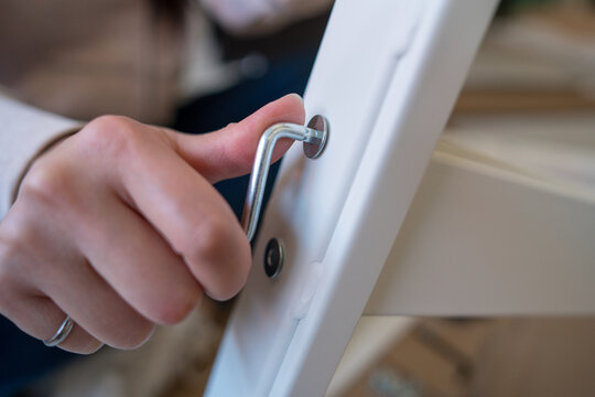 Young woman assembling a white desk at home