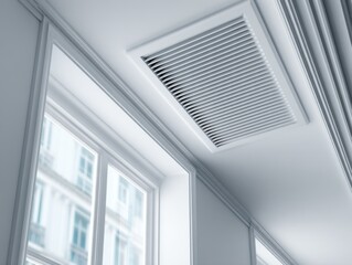Obraz premium White ceiling vent in a hallway, window with blurred building exterior view.