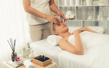 Obraz premium Caucasian woman enjoying relaxing anti-stress head massage and pampering facial beauty skin recreation leisure in dayspa modern light ambient at luxury resort or hotel spa salon. Quiescent