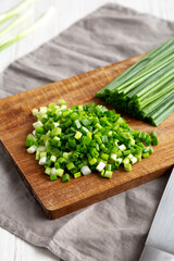 Organic Cut Green Onion Scallions on a Wooden Board, side view.