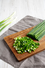 Organic Cut Green Onion Scallions on a Wooden Board, side view. Copy space.