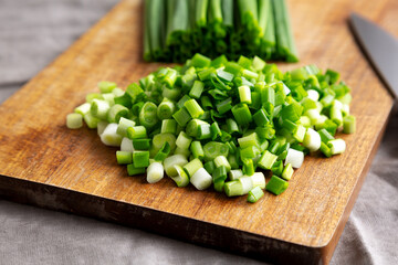 Organic Cut Green Onion Scallions on a Wooden Board, side view. Close-up.