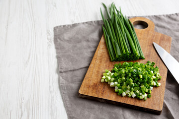 Organic Cut Green Onion Scallions on a Wooden Board, side view. Copy space.