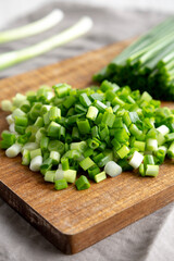 Organic Cut Green Onion Scallions on a Wooden Board, side view. Close-up.