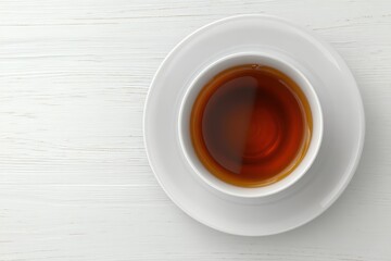 On a grey wooden background, a cup of tea is displayed from a top view, offering sufficient space for adding text or other design elements