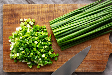 Organic Cut Green Onion Scallions on a Wooden Board, top view.