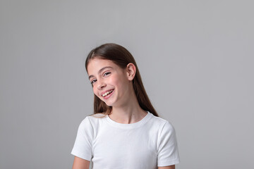 Obraz premium Beautiful teenage girl with long hair in black leggings and top in photo studio on white background. Model. Photo model. Photoshoot. Photo studio