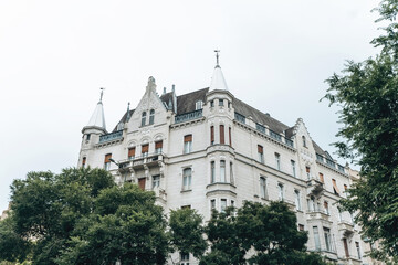 An Elegant and Historic Building Featuring Towers, Beautifully Surrounded by Lush Trees