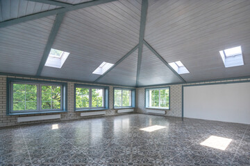 A large, bright room with high ceilings and skylights letting in natural light. The elegant...