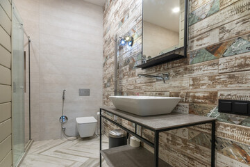 Stylish bathroom design with a modern interior. The wall is decorated with original tiles in beige and brown tones.