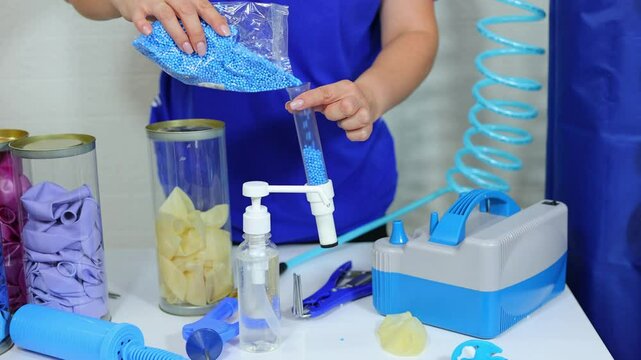 A female aerodesigner pours styrofoam into a transparent tube to decorate the ball.