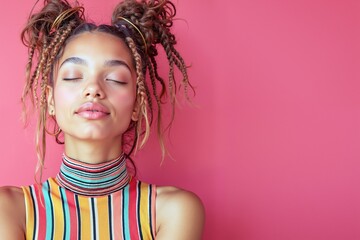 Young african female with braided hair against pink background in striped top
