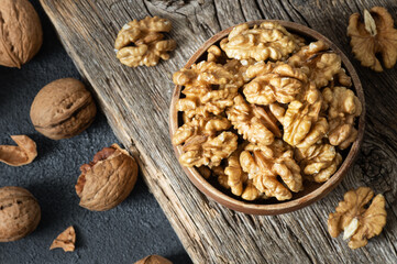 Ripe and fresh walnut kernels in bowl without shell on rustic table, healthy nut food for brain