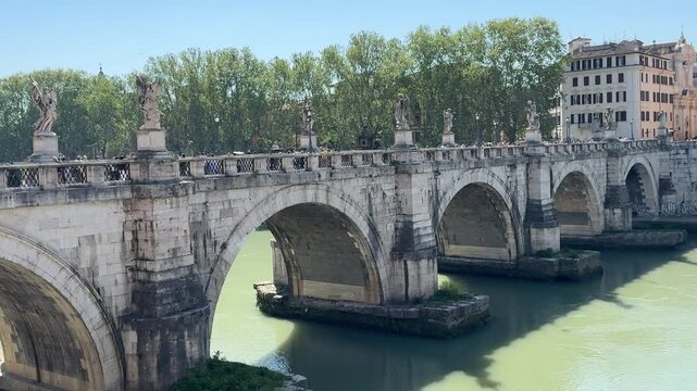 Historic bridge over the Tiber River in Rome, Italy. Elegant stone arches connect city districts, showcasing Roman engineering and scenic river views.

