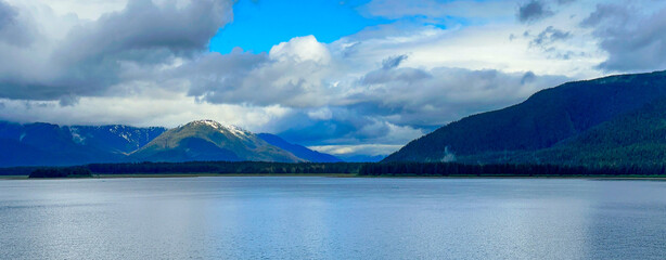 Mountains and clouds seen from a fjord in Alaska.