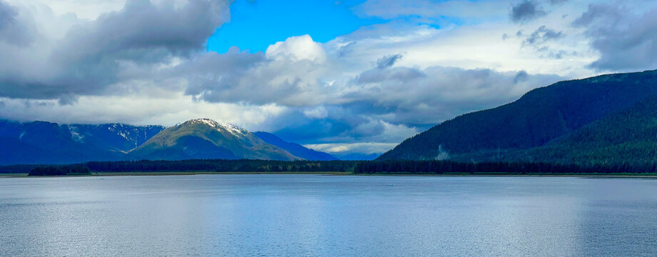 Mountains and clouds seen from a fjord in Alaska.