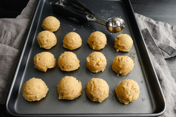 Scoops of Sugar Cookie Dough on a Sheet Pan: Non-stick baking pan with balls of cookie dough and a cookie scoop