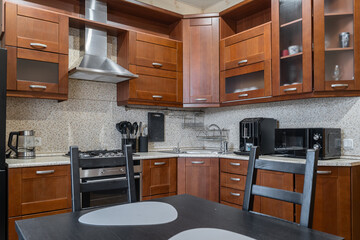 kitchen design in simple style. Built-in kitchen with wooden cabinets. Built-in appliances. Upper...