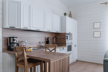 design of large wooden kitchen with white cabinets. Built-in kitchen with upper and lower cabinets, wooden countertops and backsplash. Built-in appliances. kitchen unit. built-in oven, microwave