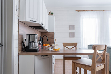 design of large wooden kitchen with white cabinets. Built-in kitchen with upper and lower cabinets, wooden countertops and backsplash. Built-in appliances. kitchen unit. built-in oven, microwave
