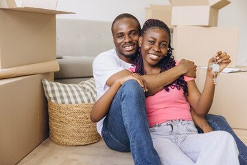 Happy african american couple showing keys of new house