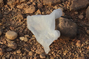 A white plastic bag on the ground, Dirty plastic waste, Plastic bag pollution
