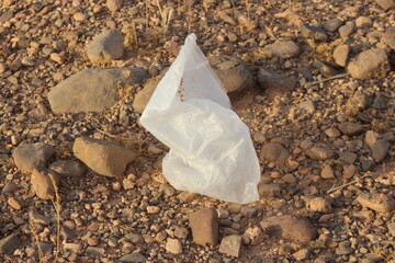 A white plastic bag on the ground, Dirty plastic waste, Plastic bag pollution