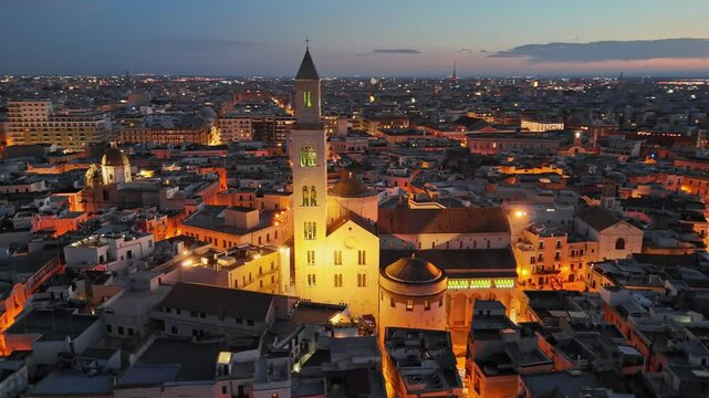 Evening sunset view of Cathedral of San Sabino in old town of Bari. Aerial shot of Bari, Puglia, Italy. City ligths and red sunset sky