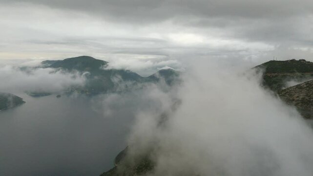 Aerial drone view of Ithaca flying through clouds foggy morning Greece Europe cinematic Vathy islands Ionian Mediterranean Sea 