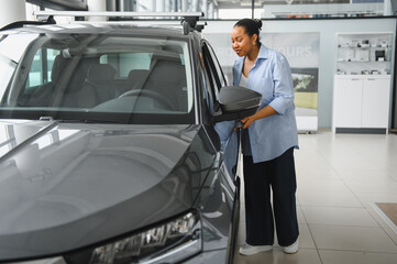 African american Customer choosing new car in dealership showroom