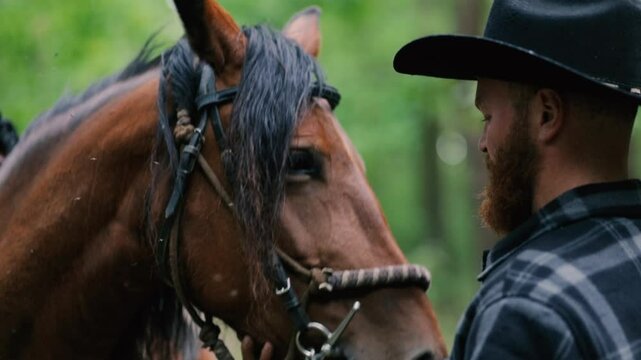 cowboy man with red beard in hat with horse close-up, friendship with animal