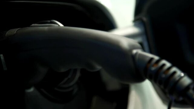 Electrical car recharging Modern electric car charging at the charger station, Electrical nozzle is inserted into an electrocar