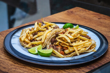 Mexican beef jerky tacos with fries on top and lemons on the side, tacos from Mexico City and Mexico State, edomex 